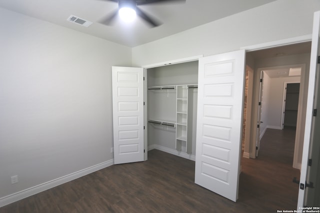 unfurnished bedroom featuring ceiling fan, a closet, and dark wood-type flooring