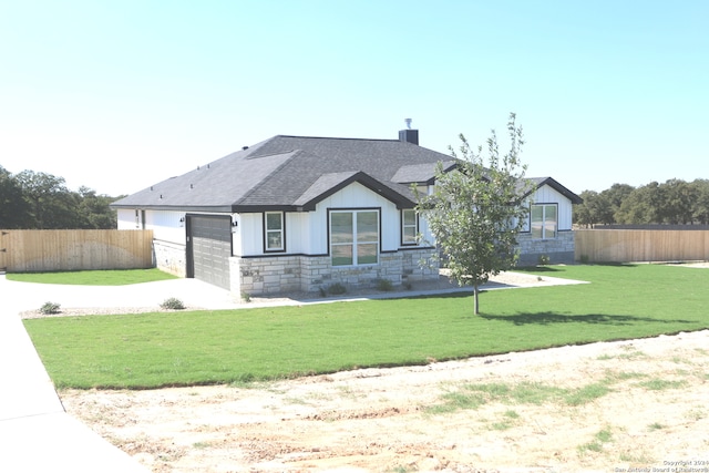 view of front of property featuring a garage and a front lawn