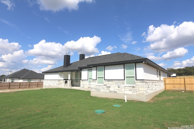 back of property with a yard and a patio