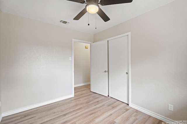 unfurnished bedroom featuring light hardwood / wood-style floors, ceiling fan, and a closet