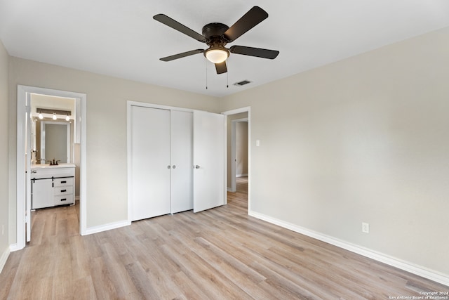 unfurnished bedroom with light hardwood / wood-style floors, connected bathroom, a closet, ceiling fan, and sink