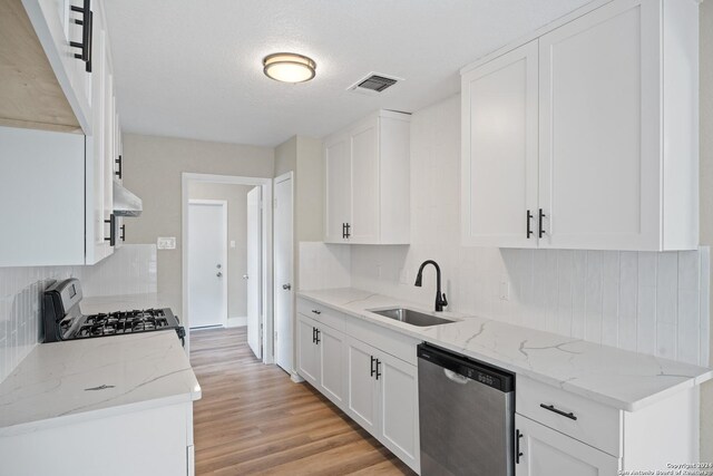 kitchen featuring light stone counters, white cabinets, stainless steel appliances, and light hardwood / wood-style flooring