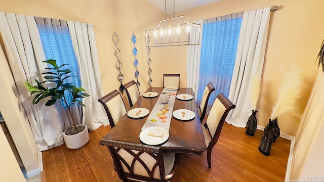 dining area with a notable chandelier and hardwood / wood-style flooring