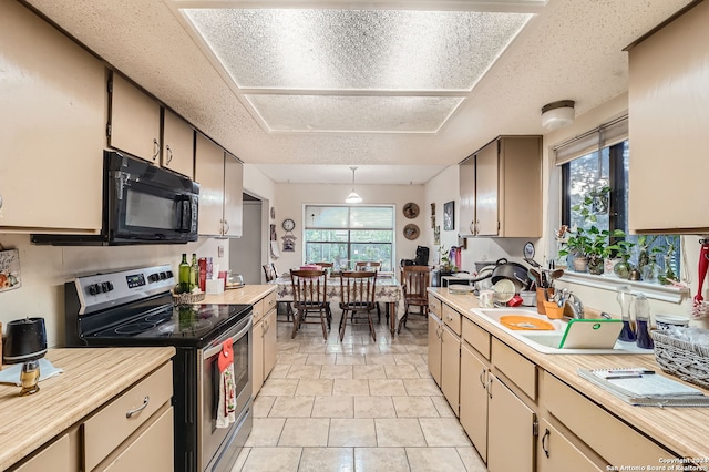 kitchen with a textured ceiling, stainless steel electric stove, and light tile patterned floors