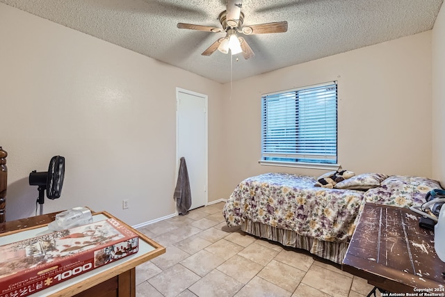 tiled bedroom featuring a textured ceiling and ceiling fan