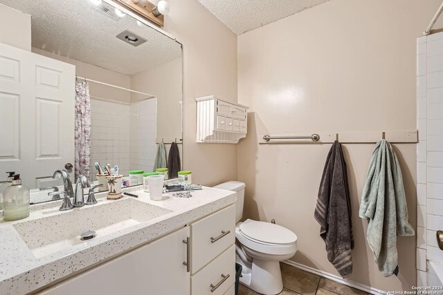 bathroom featuring walk in shower, vanity, toilet, and a textured ceiling