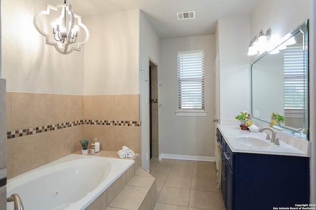 bathroom featuring vanity, an inviting chandelier, tiled tub, and tile patterned floors