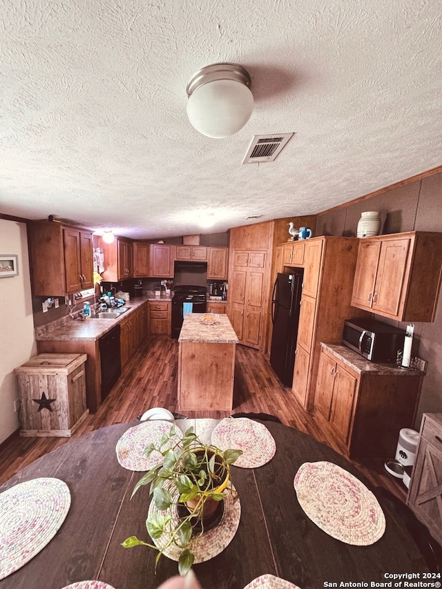 interior space with a textured ceiling, sink, and dark hardwood / wood-style flooring