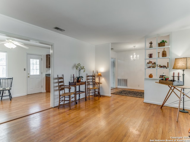 entrance foyer featuring wood-type flooring and ceiling fan with notable chandelier