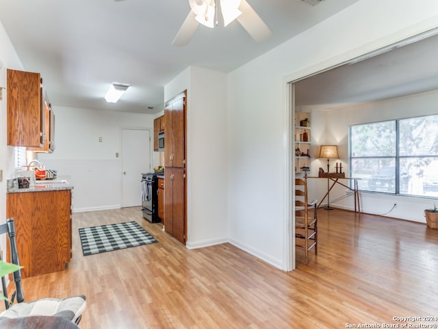 kitchen featuring appliances with stainless steel finishes, light hardwood / wood-style floors, and ceiling fan