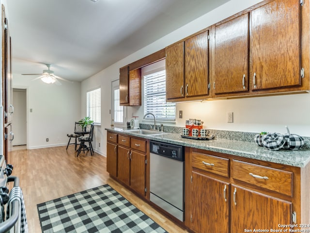 kitchen featuring light wood-type flooring, stainless steel dishwasher, ceiling fan, sink, and range