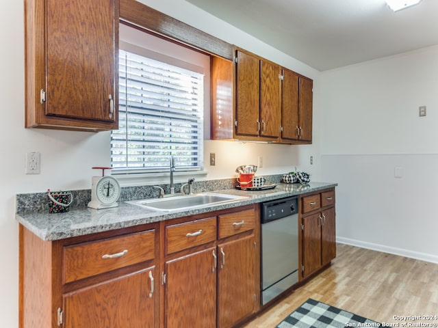 kitchen with light hardwood / wood-style flooring, stainless steel dishwasher, and sink