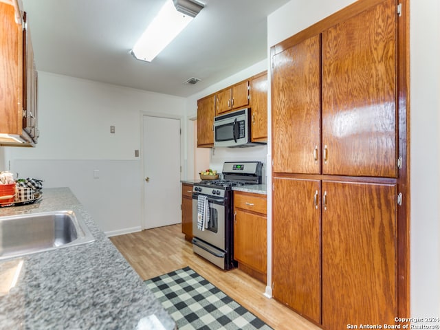 kitchen with stainless steel appliances and light hardwood / wood-style floors