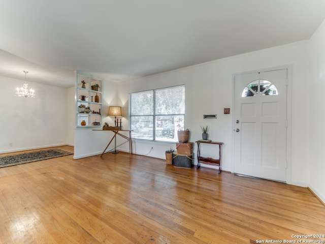 foyer entrance with an inviting chandelier and hardwood / wood-style flooring