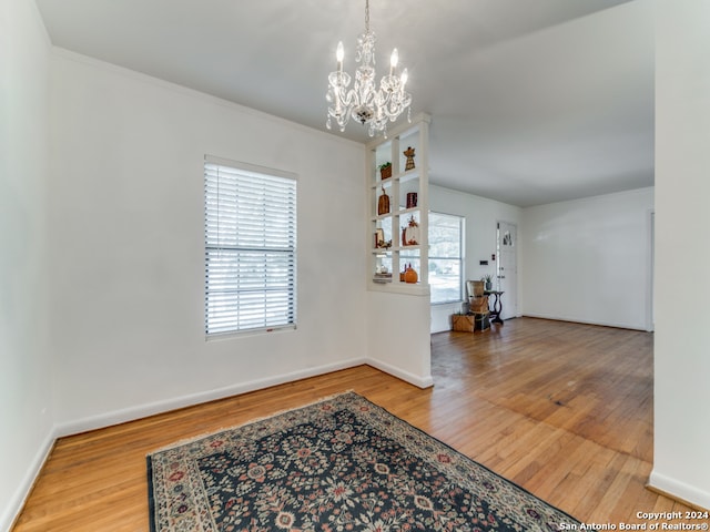 interior space with a chandelier, hardwood / wood-style flooring, and crown molding