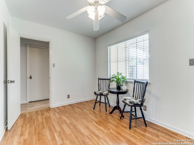 living area with ceiling fan and light hardwood / wood-style floors