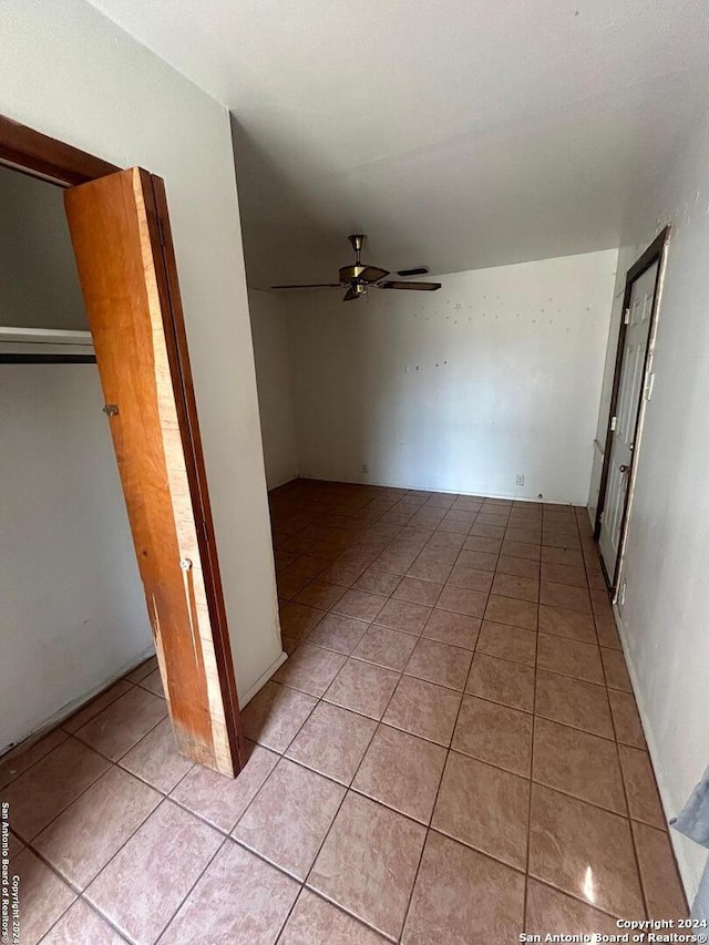 interior space with light tile patterned floors, ceiling fan, and a closet