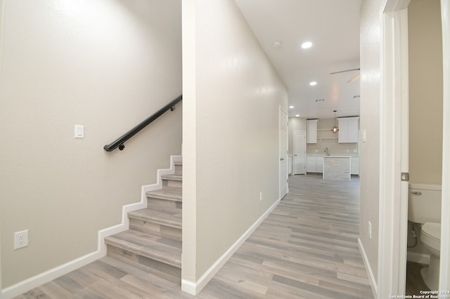 hallway with sink and light hardwood / wood-style flooring