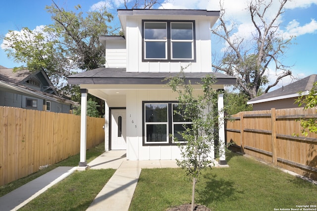 rear view of house featuring a lawn