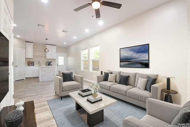 living room featuring light hardwood / wood-style flooring and ceiling fan