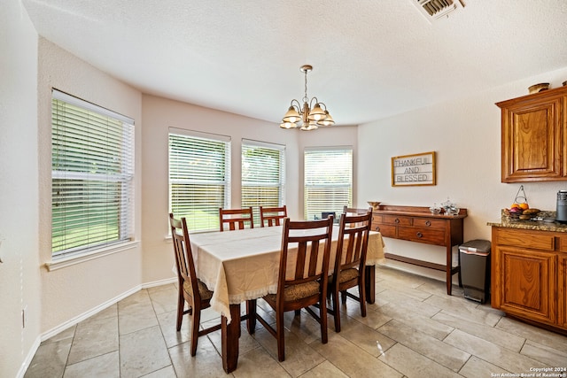 dining room featuring an inviting chandelier and a textured ceiling