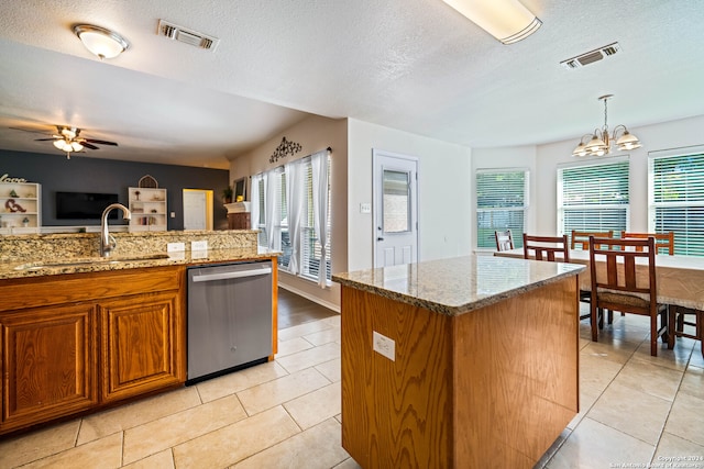 kitchen with pendant lighting, sink, a kitchen island, stainless steel dishwasher, and ceiling fan with notable chandelier