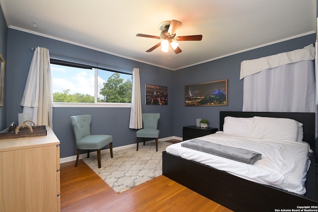 bedroom featuring ornamental molding, wood-type flooring, and ceiling fan