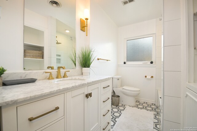 bathroom featuring walk in shower, vanity, and toilet