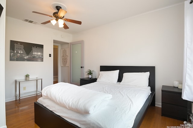 bedroom featuring ornamental molding, ceiling fan, and dark wood-type flooring