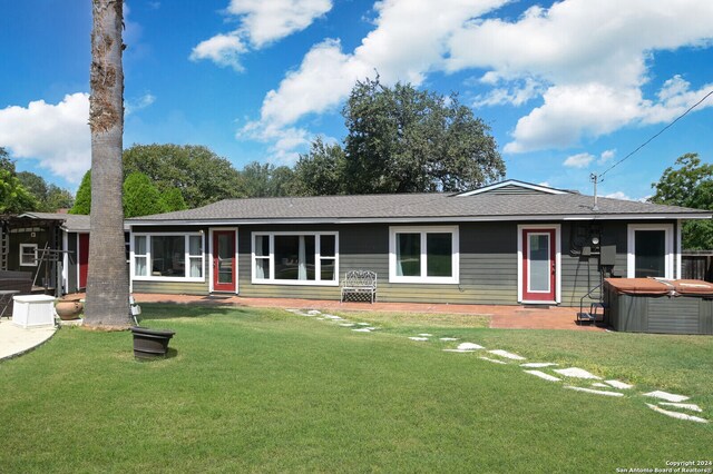 ranch-style house featuring a hot tub, a patio, a front yard, and central air condition unit