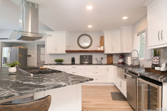 kitchen featuring light hardwood / wood-style flooring, stainless steel appliances, white cabinets, and island range hood