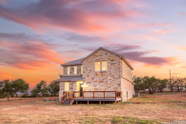 back house at dusk featuring a wooden deck