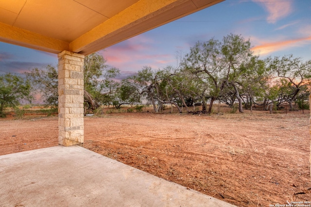 yard at dusk featuring a patio