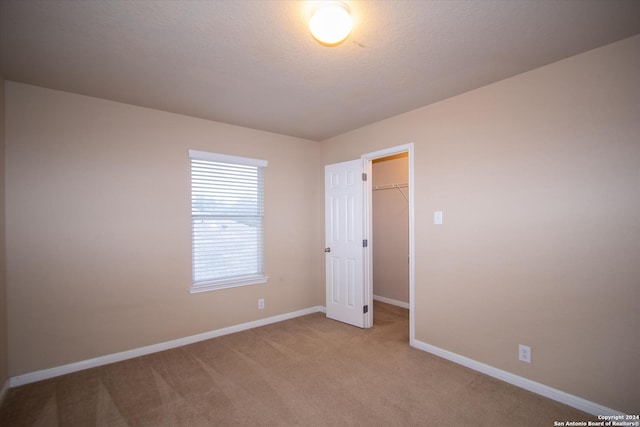 9171 Everton, San Antonio, TX 78245 - unfurnished bedroom with baseboards, a closet, a spacious closet, and light colored carpet