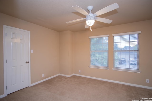 unfurnished room featuring ceiling fan and light carpet