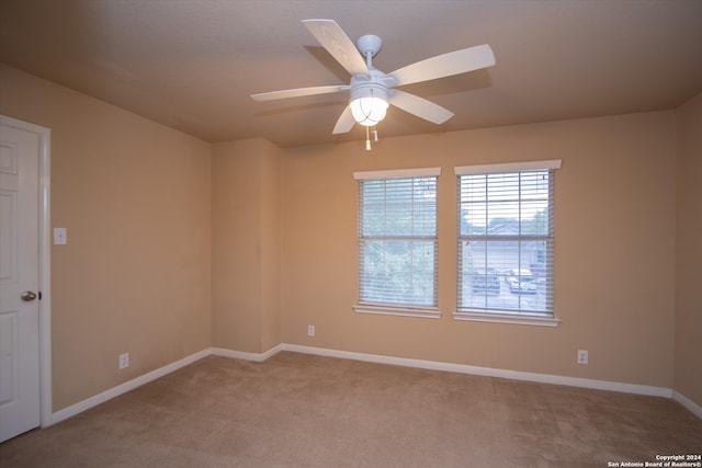 carpeted spare room with ceiling fan