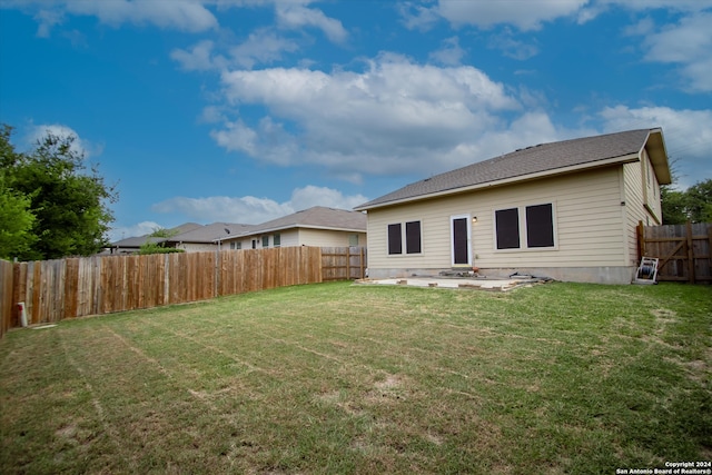 rear view of property featuring a patio area and a yard