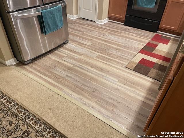 interior details with light hardwood / wood-style flooring, fridge, and range