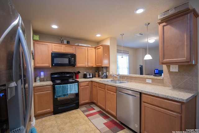 kitchen with black appliances, decorative backsplash, sink, and hanging light fixtures