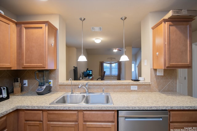 kitchen featuring tasteful backsplash, sink, stainless steel dishwasher, and decorative light fixtures