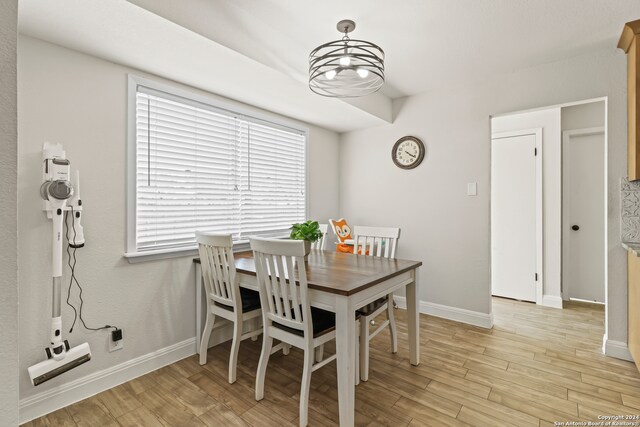 dining area with an inviting chandelier and light hardwood / wood-style flooring