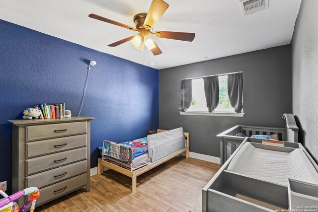 bedroom with light hardwood / wood-style flooring and ceiling fan