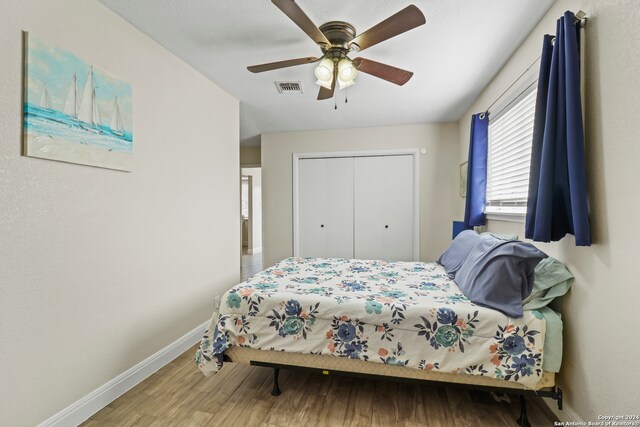 bedroom featuring ceiling fan, hardwood / wood-style flooring, and a closet