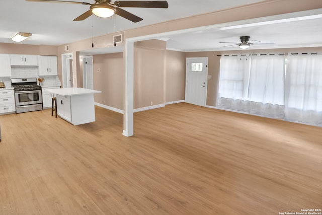 unfurnished living room with light hardwood / wood-style floors, ornamental molding, and ceiling fan