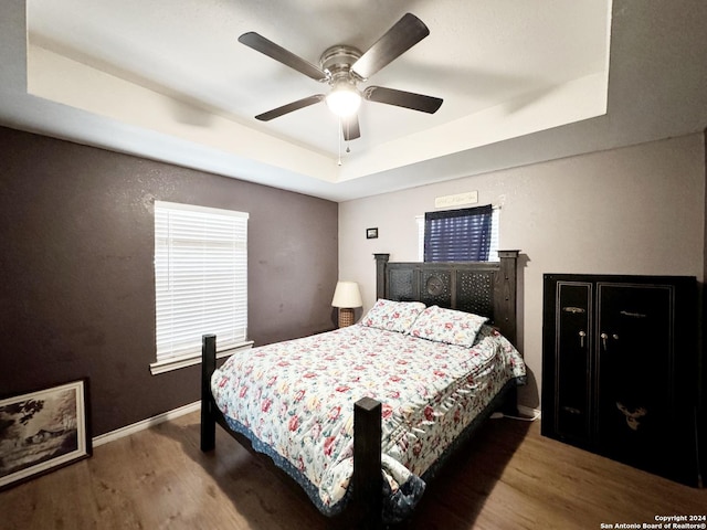 133 Rio Grande St, Uvalde, TX 78801 - bedroom with a tray ceiling, wood finished floors, baseboards, and ceiling fan