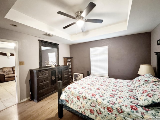 133 Rio Grande St, Uvalde, TX 78801 - bedroom featuring a raised ceiling, wood finished floors, a ceiling fan, and baseboards