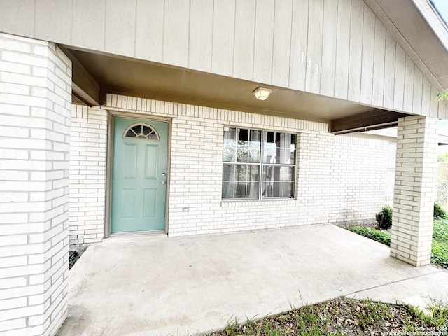 view of exterior entry featuring a patio area