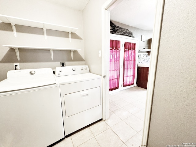 washroom featuring light tile patterned floors and washing machine and clothes dryer