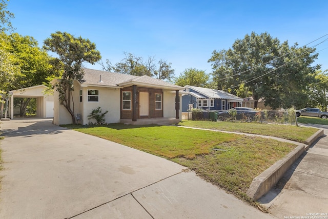 ranch-style home with a front yard, a garage, and a carport