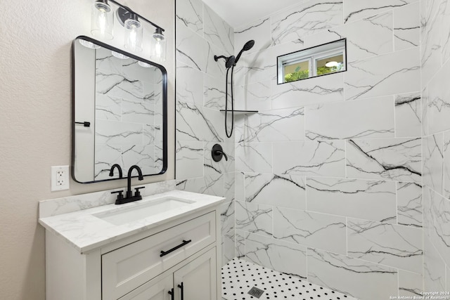 bathroom with a tile shower and vanity